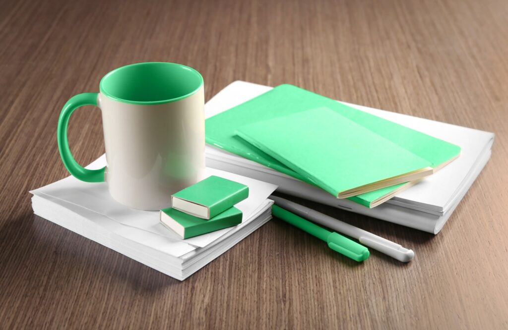 Zelenobílý hrnek, zápisníky, propisky vhodné pro hydloglazuru